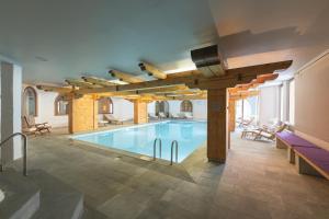 蓬特雷西纳罗萨兹酒店的一座带木梁的建筑中的大型游泳池