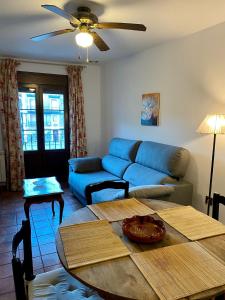 拉武埃尔达Apartamentos Turismo Rural Casa Alfós的客厅配有蓝色的沙发和桌子