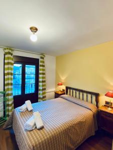 拉武埃尔达Apartamentos Turismo Rural Casa Alfós的一间卧室配有一张床,上面有两条毛巾