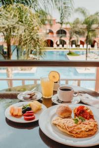 伊察Hacienda San Juan Resort的餐桌,带两盘食物和一杯咖啡的桌子