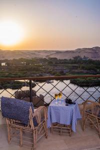 阿斯旺ASWAN NILE PALACE (swimming pool-rooftop-Nile view)的阳台上的桌椅享有日落美景