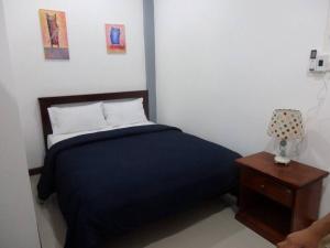 沙美岛Judith's 2 bedroom family home, sleeps 6的一间卧室配有一张床和一个带四柱床的木制床头柜。