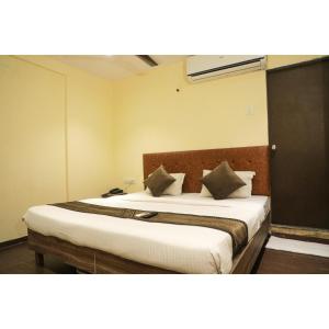 纳威孟买Hotel Pub Street Inn的卧室配有一张带白色床单和枕头的大床。