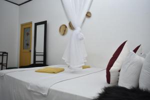 锡吉里亚斯吉利岩石边民宿的一间卧室配有一张带白色床单和镜子的床