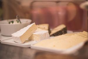 维拉巴萨艾玛西丝德来克酒店的桌上的一盘奶酪,放着一碗食物