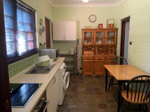 CarramarBentworth Lodge的厨房配有水槽、桌子和台面
