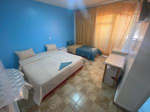 亚喀巴City Center Hostel的蓝色卧室,配有床和椅子