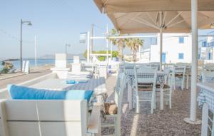 斯卡拉拉扎海滩酒店的一间设有白色桌椅的海洋餐厅