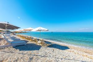 斯卡拉拉扎海滩酒店的海滩上的一组椅子和遮阳伞