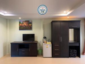 奈扬海滩Naiyang Seaview Place Resort的一间配备有冰箱、橱柜和时钟的客房