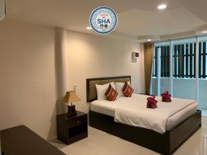 奈扬海滩Naiyang Seaview Place Resort的一间卧室,床上有红色的弓