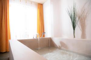 劳特布龙嫩希尔伯亨酒店的浴室配有带水的浴缸。