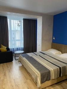 切尔尼戈夫Magic Days Apartments的一间卧室设有一张大床和蓝色的墙壁
