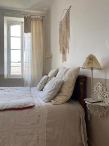 CoursanLe logis blanc bed&breakfast的一间卧室配有一张带灯和窗户的床