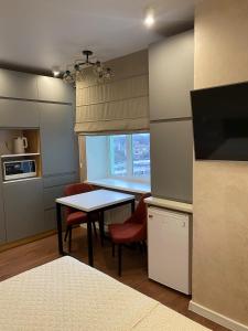 切尔尼戈夫Magic Days Apartments的厨房配有桌椅和窗户。