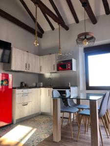 托莱多Mirador de San Juan的厨房配有桌椅和红色冰箱。