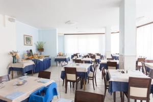 切尔维亚Hotel Real的一间配备有蓝色桌椅的用餐室