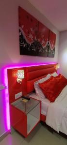 峇六拜Penang karaoke Ruby Townhouse 1st floor的一间卧室配有一张红色的床和玻璃桌
