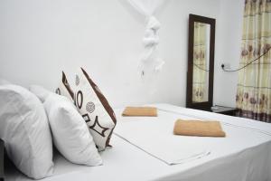 锡吉里亚斯吉利岩石边民宿的白色的床和白色枕头