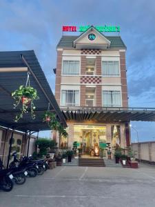 朔庄XUÂN HUỲNH 3 Hotel的一辆摩托车停在酒店前面的酒店