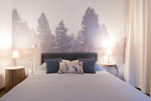 拉罗谢尔Terre en Vue的卧室配有一张墙上树木环绕的床