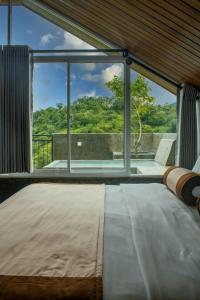 康提Kandy Victoria Eco Resort的一间卧室设有一张床和一个大窗户