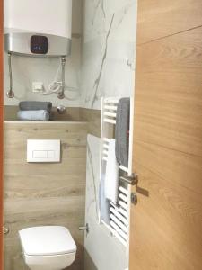 别拉什尼察Rest Apartman, Bjelašnica的一间带卫生间的浴室和一个带毛巾的门