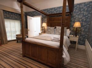 考布里奇The Bear, Cowbridge的一间卧室配有天蓬床和蓝色壁纸