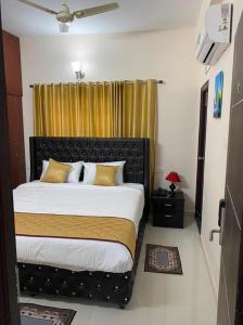 蒂鲁帕蒂OM SRINIVASA - TRULY HOMESTAY的一间卧室配有一张带黄色窗帘的大床