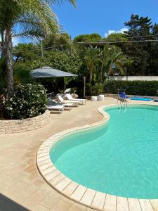 托雷奇安卡Buen Retiro - Villa con piscina vicino Lecce a 450m dal mare的一个带椅子和桌椅的大型游泳池