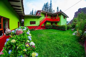 乌鲁班巴Happy Land Valle Sagrado的院子里鲜花盛开的绿色和红色房子