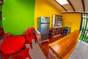 乌鲁班巴Happy Land Valle Sagrado的厨房配有桌子、红色椅子和冰箱