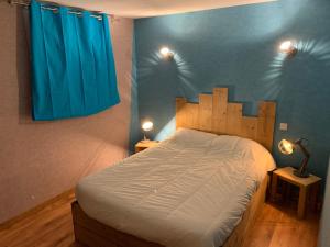 热拉梅Appartement 6 pers - Les 4 Loups au pied des pistes的一间卧室配有一张带蓝色窗帘的大床