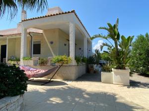 托雷奇安卡Buen Retiro - Villa con piscina vicino Lecce a 450m dal mare的前面有一把伞的房子