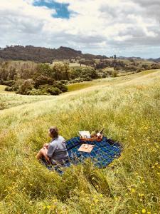 怀托摩洞穴Aranui Farmstay的坐在野外毯子上的人