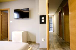 伊利扎Apartments "Our Place" Sarajevo的一间卧室配有一张床,墙上配有电视