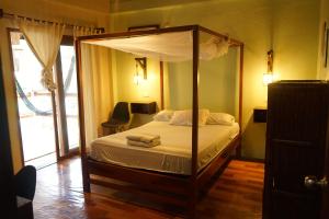蒙塔尼塔Sapa Inka的一间卧室配有一张带毛巾的天蓬床。