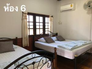 Ban Hua Nam Mae SakutPimpa House的一间卧室设有两张床和窗户。