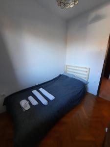 萨格勒布Apartments Mateo的一间卧室配有一张床,并备有2个拖鞋