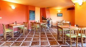 贝内茨科达纳旅馆的餐厅拥有橙色的墙壁和桌椅