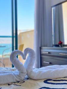 提比里亚Star of Tiberias的床上的两条毛巾天鹅形成心