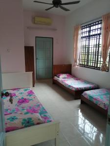 麻坡JOYFIN homestay roomstay muar的带三张床和天花板的客房