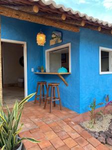 路易斯科雷亚Vilarejo Macapá Chalés的前面有凳子的蓝色房子