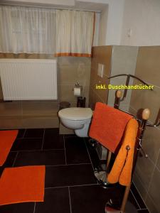 路德斯塔德·威特比DIE Ferienwohnung - Wittenberg an den Elbwiesen的一间带卫生间和橙色毛巾的浴室