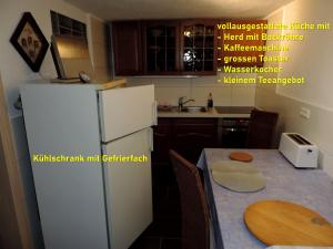 路德斯塔德·威特比DIE Ferienwohnung - Wittenberg an den Elbwiesen的厨房配有白色冰箱和桌子