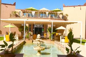 马拉喀什Villa Kesh Evasion Marrakech的一座建筑前有喷泉的酒店