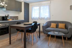 圣布里厄Bel appartement idéalement placé Saint-Brieuc, wifi, parking gratuit的厨房以及带桌子和沙发的客厅。