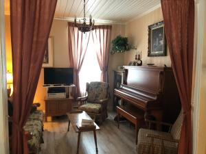 三河城勒克莱尔度假屋的客厅配有钢琴和椅子