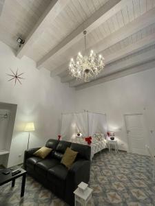 巴列塔CasArcieri72的客厅配有黑色沙发和吊灯。