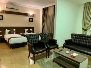 安曼Ream Hotel Amman的酒店客房配有一张床、一张沙发和椅子。